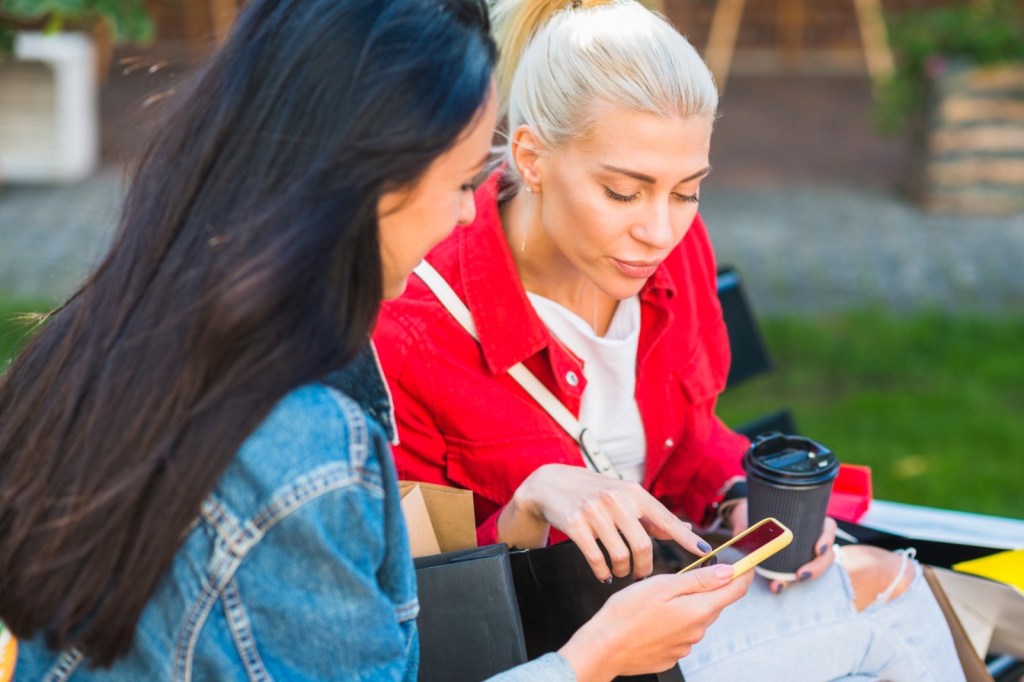 two women looking at phone app together