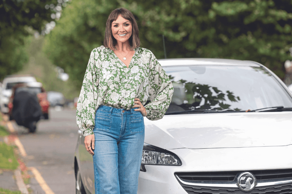 Martine McCutcheon standing in front of a car