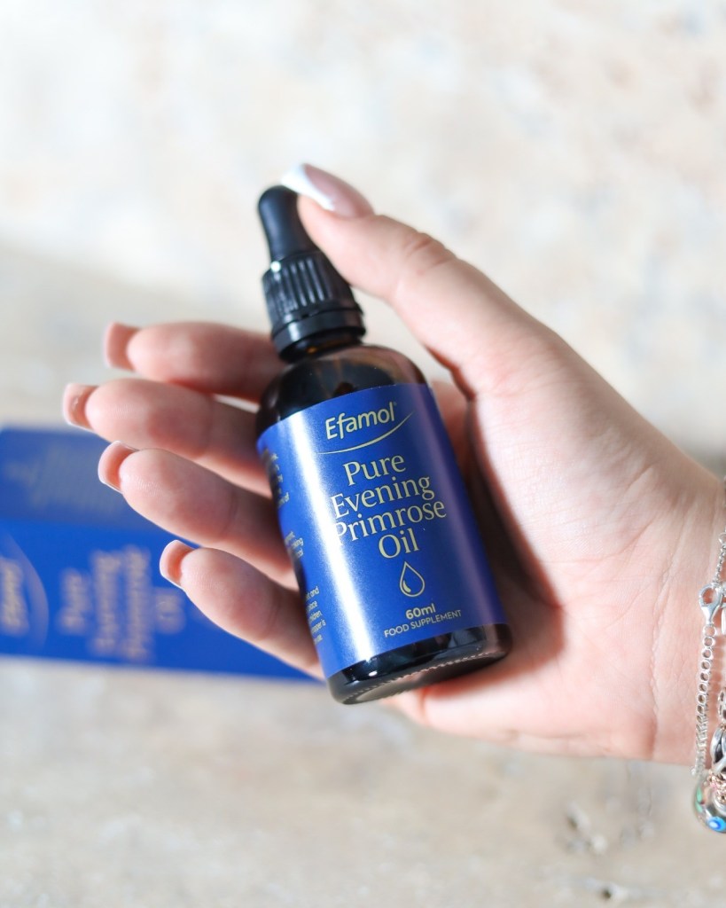 hand holding Efamol® NEW Evening Primrose Oil Dropper