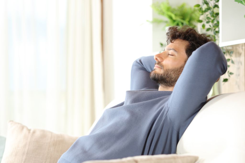 man relaxes on sofa