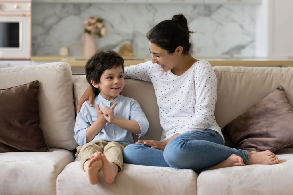 mum and son sat together on sofa talking