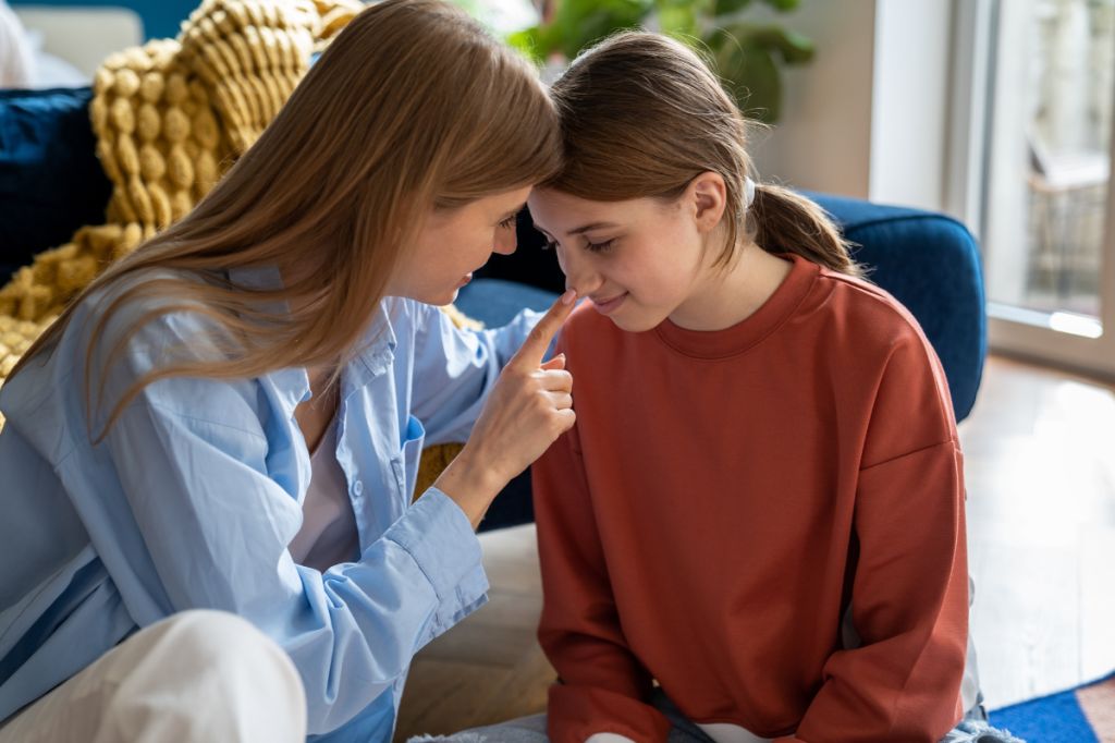 Mum taps nose of daughter showing understanding