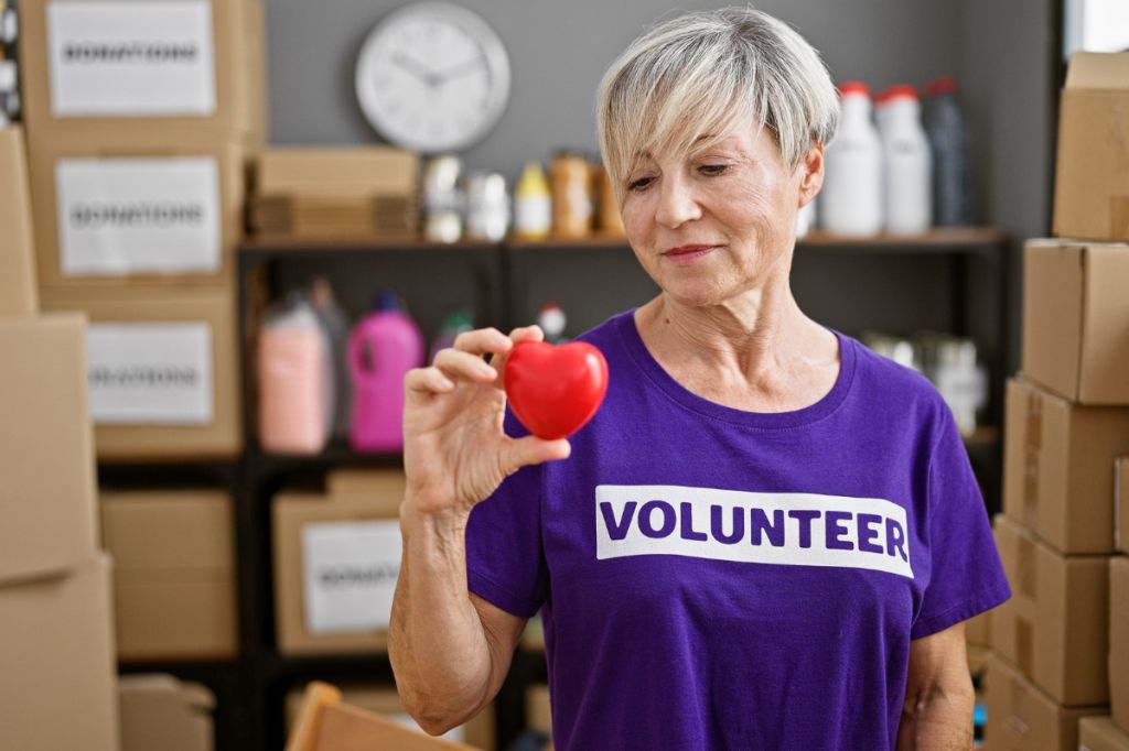 Woman volunteers for charity, surrounded by boxes of donations
