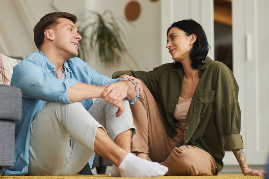 couple sit on floor talking