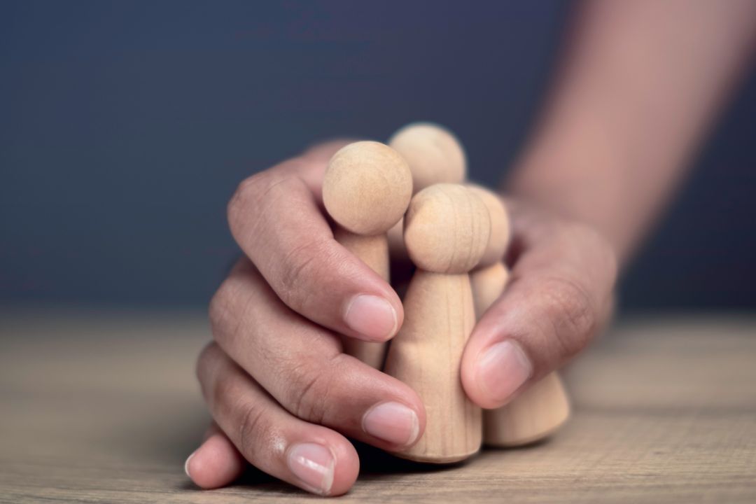 hand grips family of wooden dolls tightly