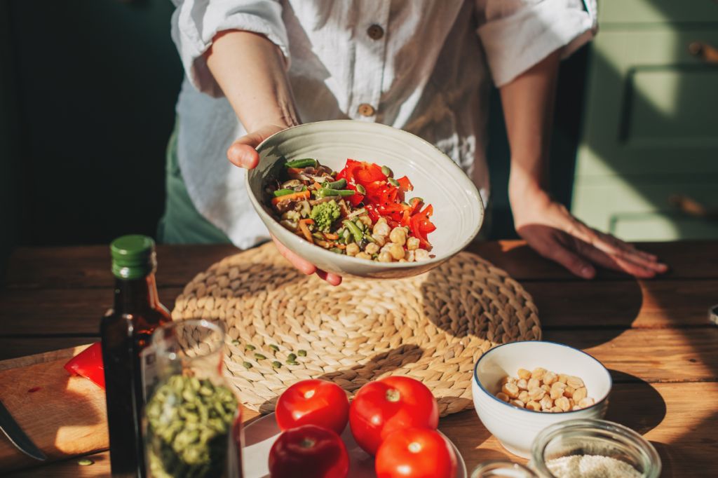 Man holds a healthy bowl of grains, pulses and vegetables