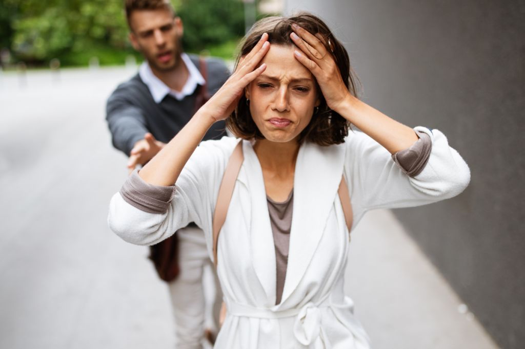 man chasing after crying woman