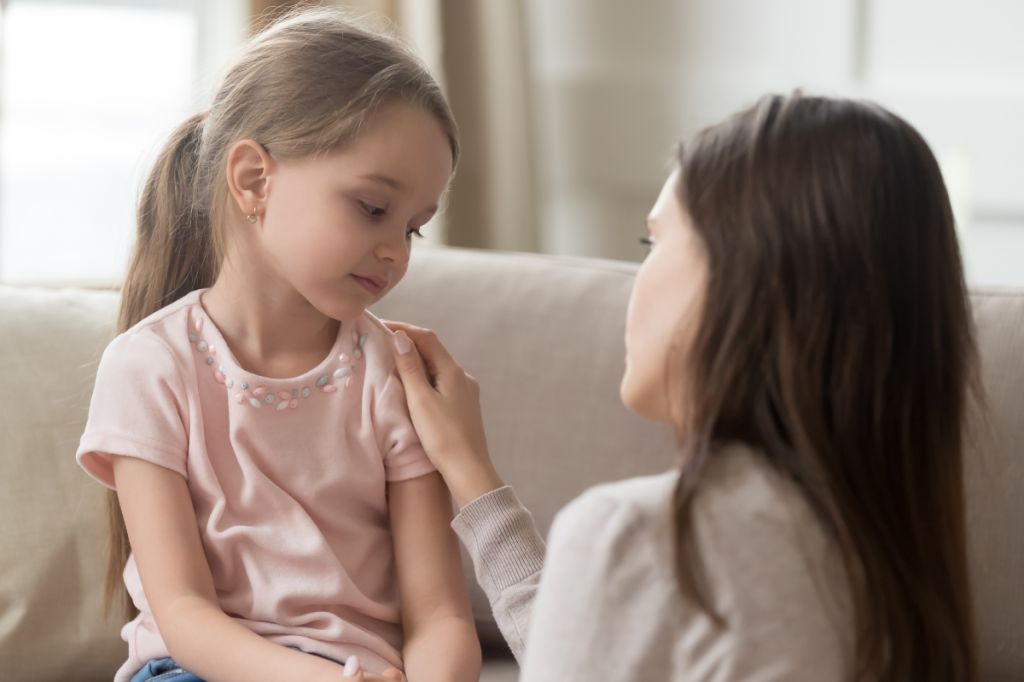mother and daughter talk, girl looks sad as mother apologises