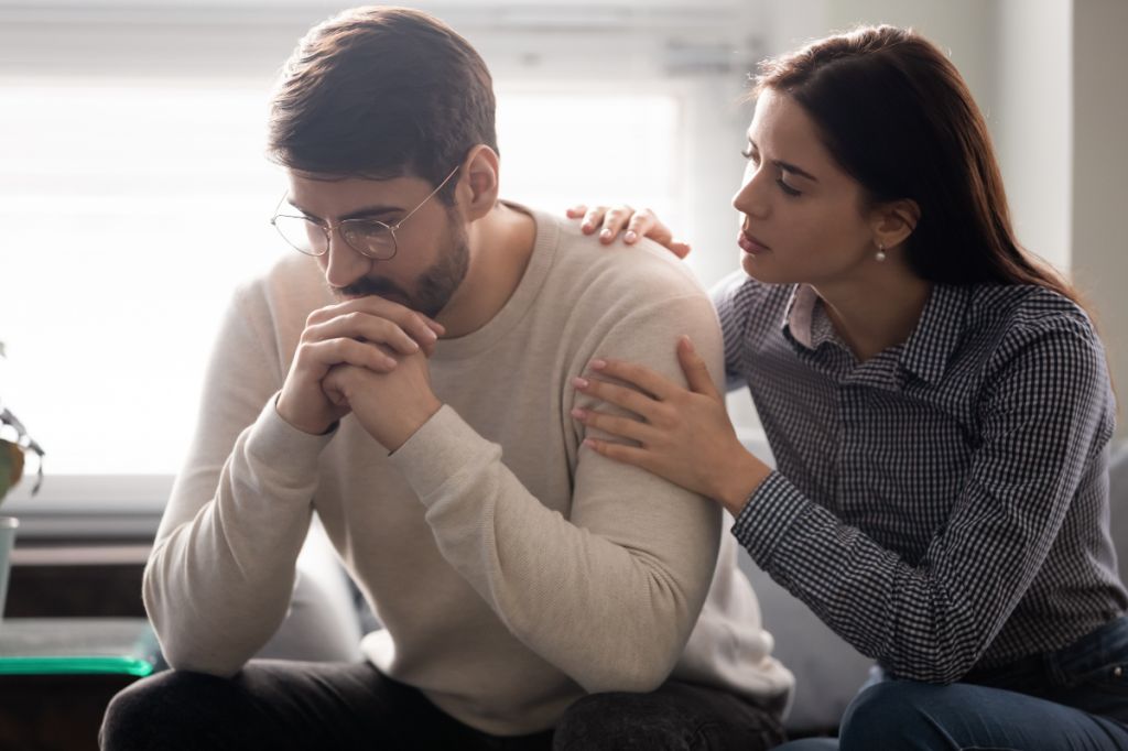 woman comforts man