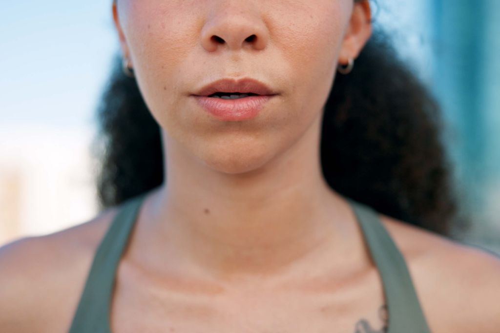 woman purses her lips as she gently blows out