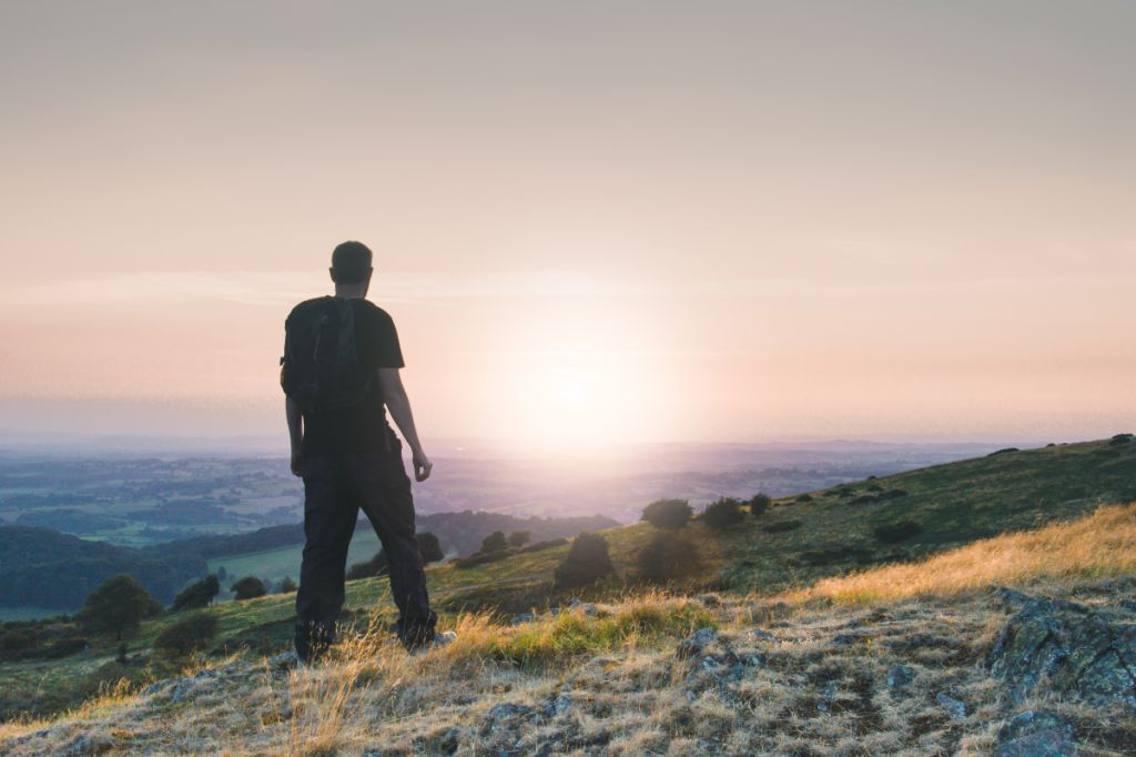 man looks out across a beautiful valley