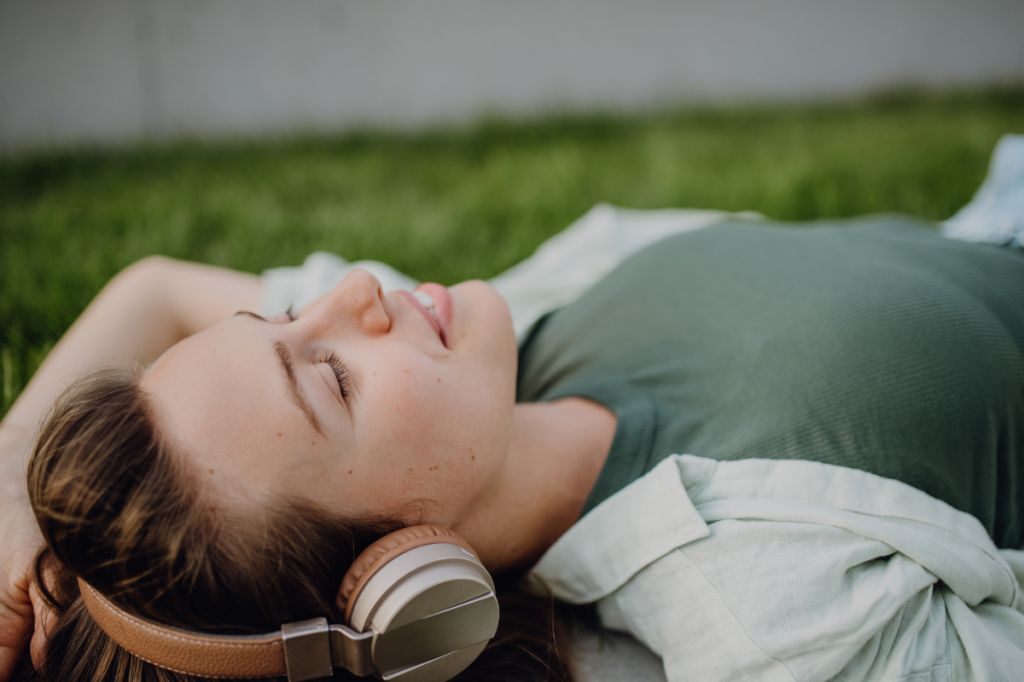 lying on the grass listening to music on headphones