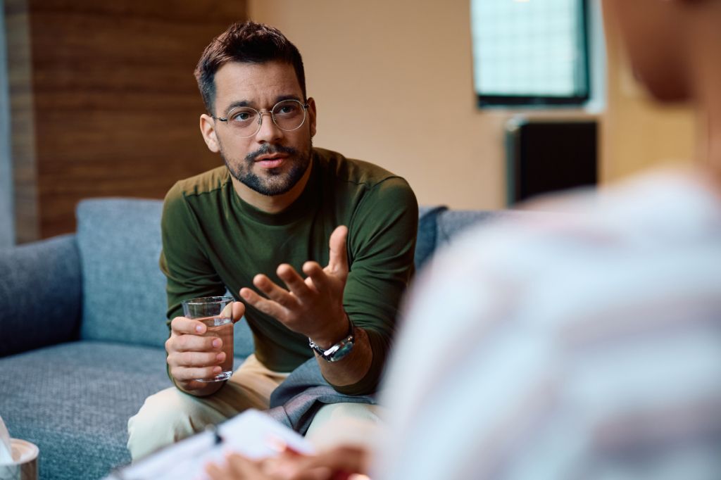 man holds out hand talking to another man