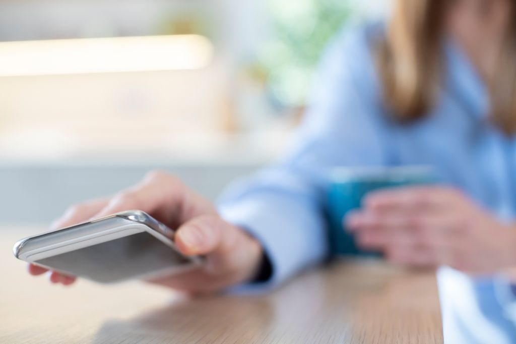 woman purposefully lays phone face down on table