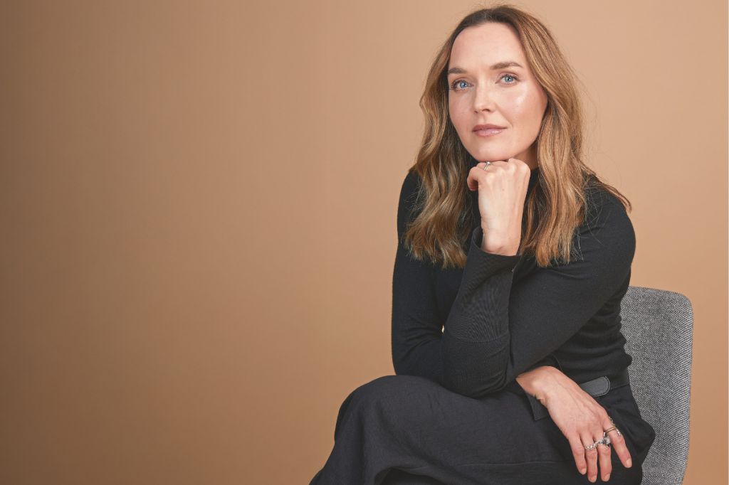 Former Olympic Champion cyclist Victoria Pendleton, a middle aged woman, sits with her chin on her hand looking straight at us
