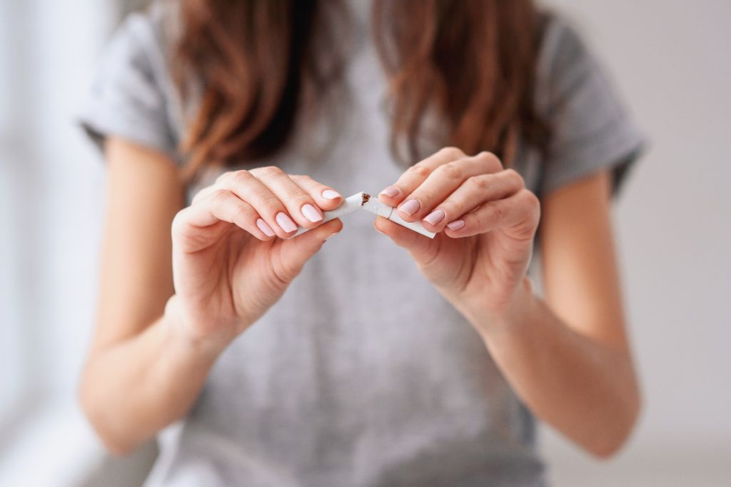Woman breaks cigarette in two