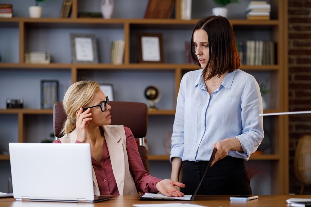 two women arguing at work. narcissism spotting in the workplace concept