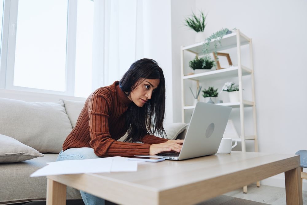 woman concentrating on work at home, she looks tired and stressed out with her career