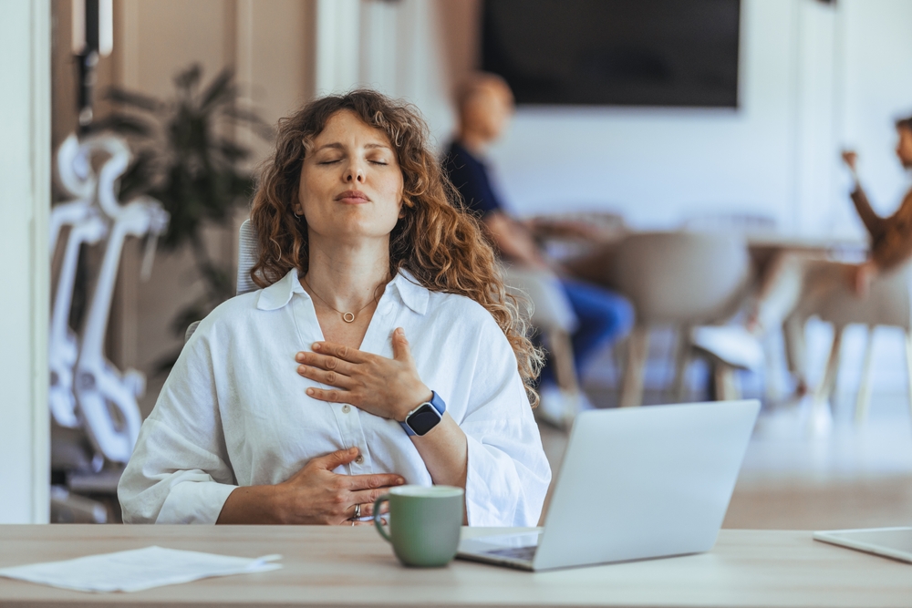 woman at work managing stress and burnout with breathing exercises