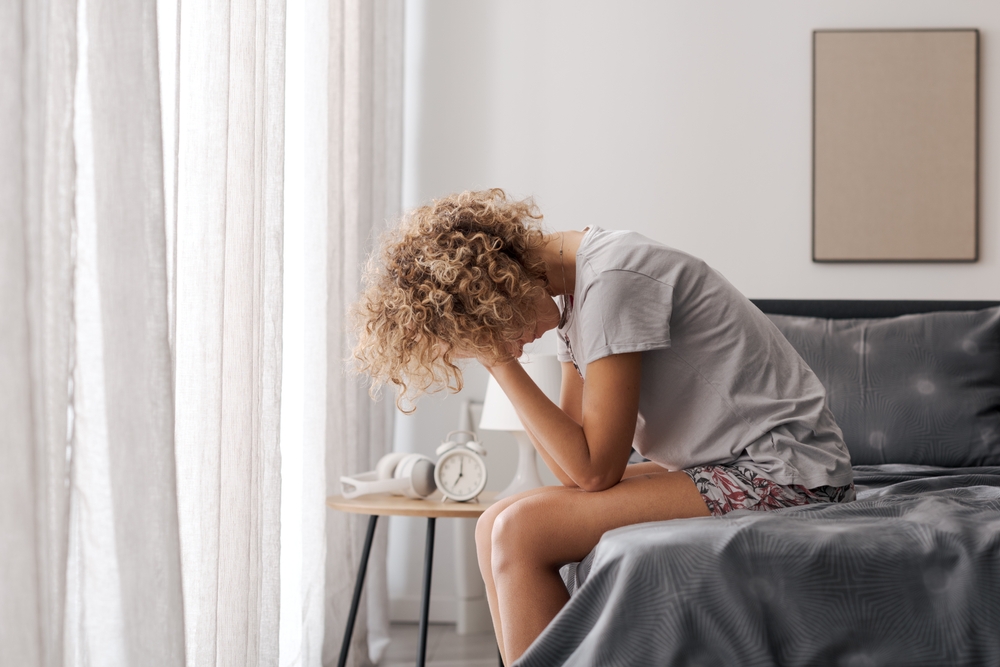 woman waking up feeling exhausted and stressed, signs her nervous system is dysregulated