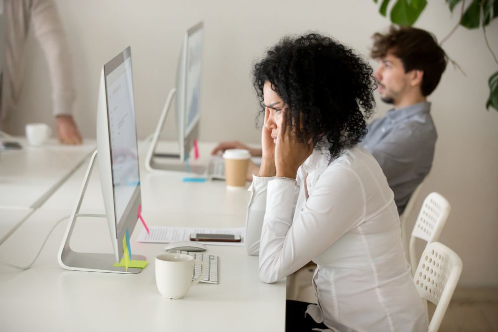 Picture of a woman looking stressed as she looks at a computer