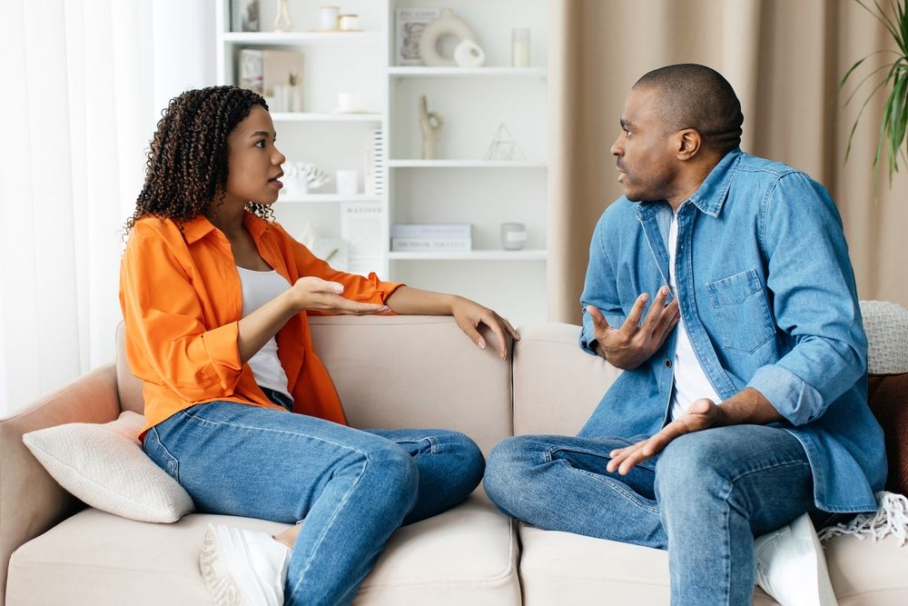 a photograph of a couple arguing on the couch