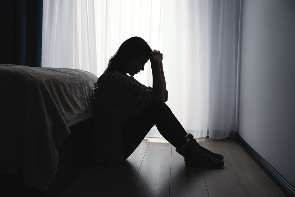 Woman suffering from depression in a dark room