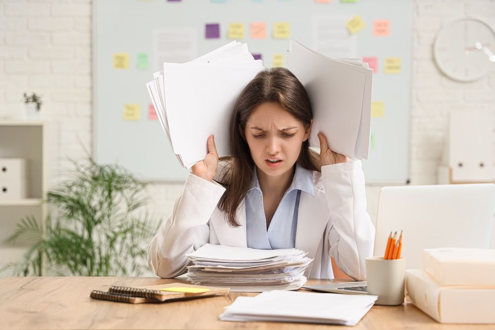 Woman overwhelmed by organisation and sticky notes at work
