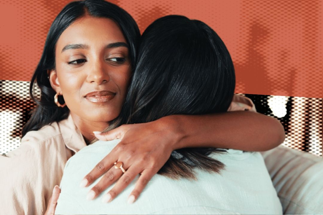 Two women embracing, but one of them looks suspicious