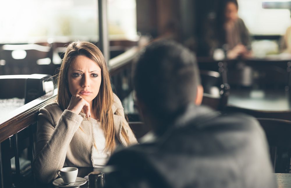 two friends at a bar, a woman is looking